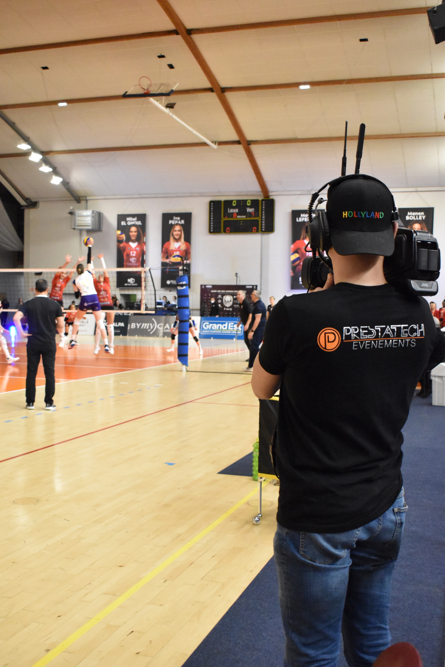 caméraman filmant un match de volley féminin